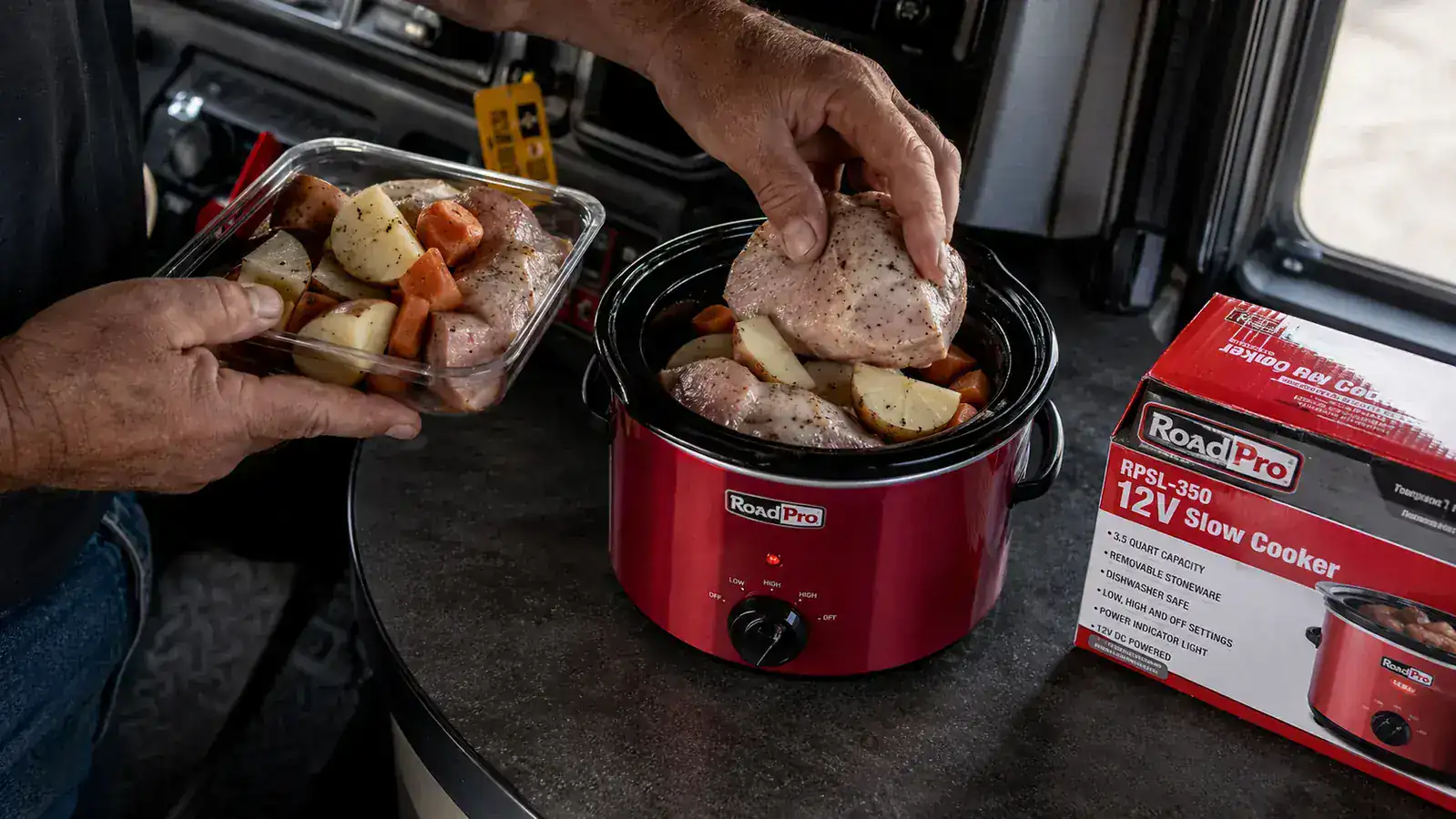 Chicken thighs, potatoes, and carrots loaded into a small red 12V slow cooker crock on a cab shelf