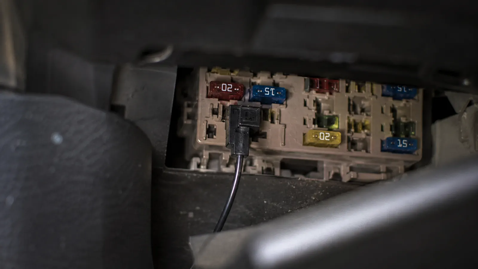 Hardwire fuse tap kit connected to a truck fuse box with a yellow constant-power fuse slot