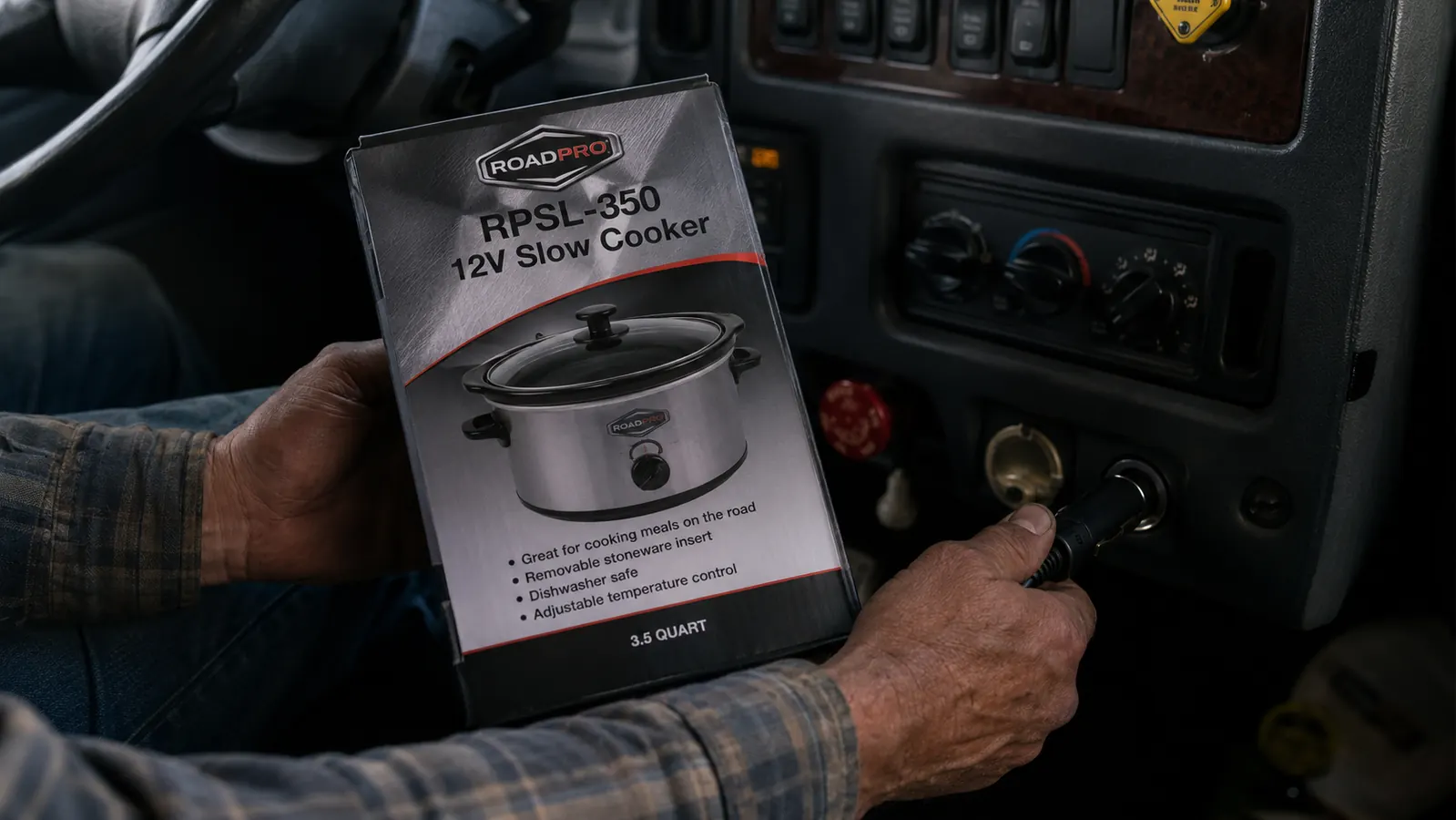 Close-up of a hand plugging a 12V slow cooker cord into a truck cigarette lighter socket