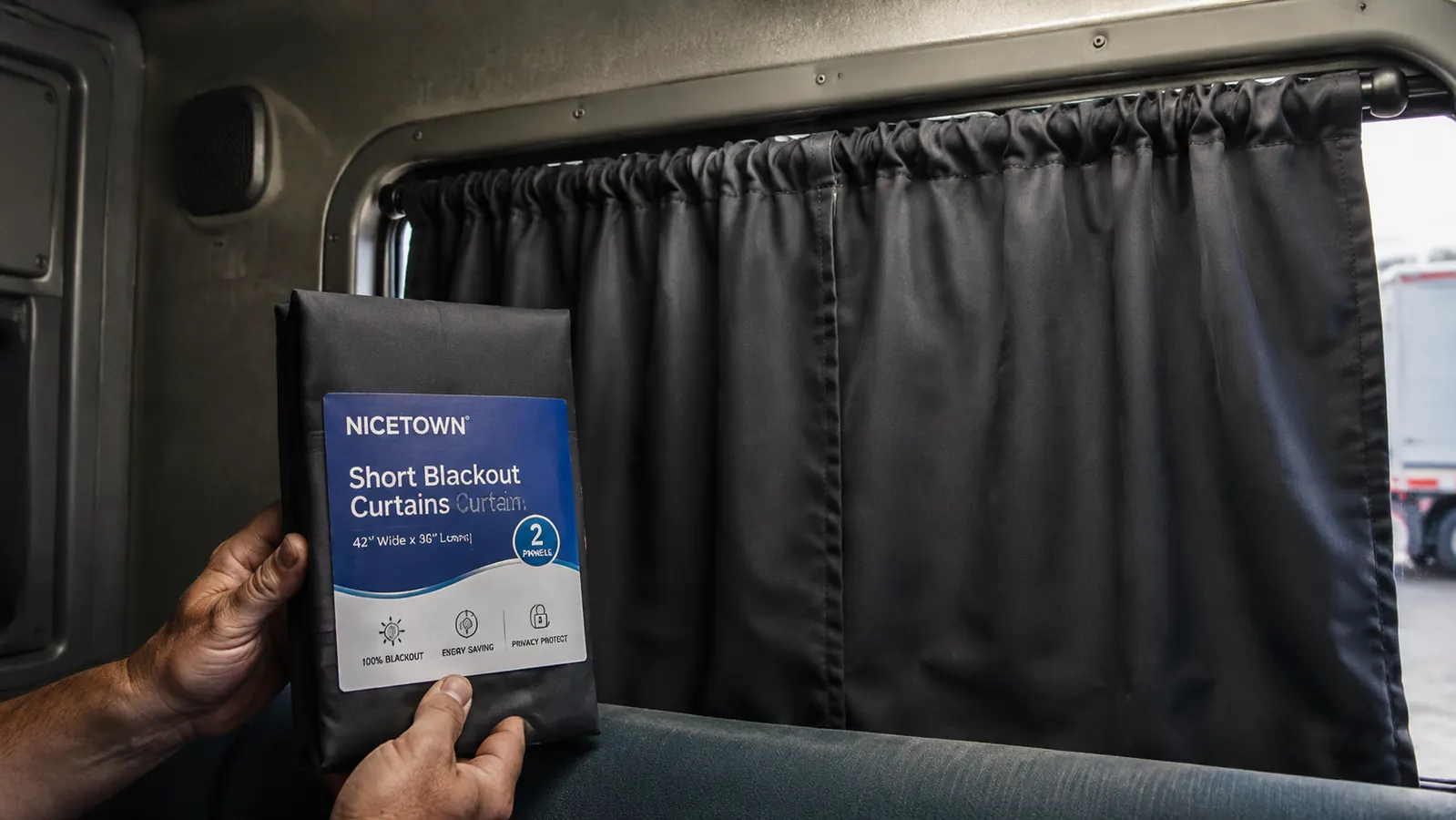 Pair of dark gray NICETOWN blackout panels hanging from a tension rod inside a sleeper cab window frame